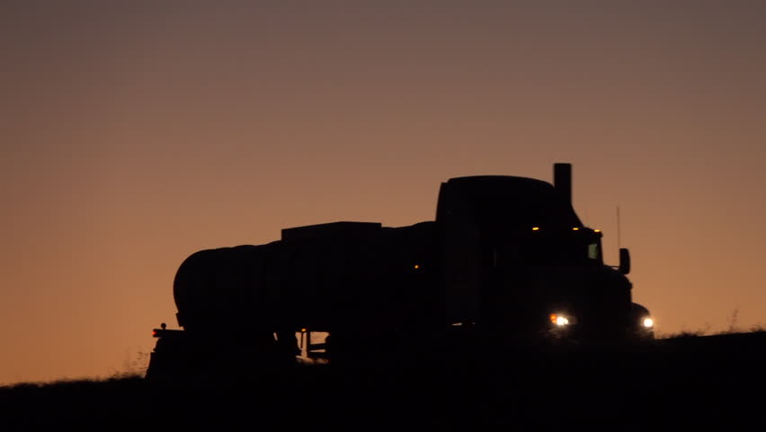 SLOW MOTION CLOSE UP: Silhouetted tank truck driving uphill transporting liquefied load on the empty highway during the night. Car overtaking oil tanker traveling & shipping freight across the country | Shutterstock HD Video #26178275
