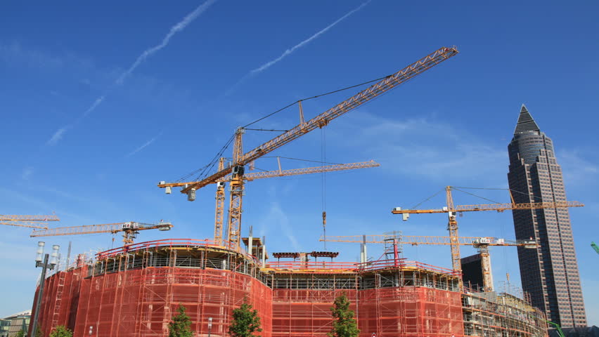 Time-lapse construction site with several cranes on a sunny day with office