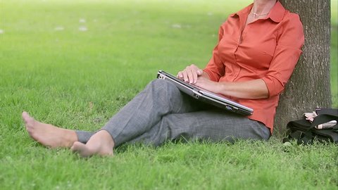 A woman in a park using a laptop