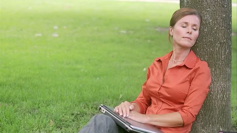 A woman in a park using a laptop