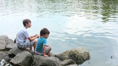 Boys playing on the banks of the river on a summer day