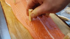 Blazing salmon, tapping glace salmon fillet on a wooden plate, at a restaurant kitchen