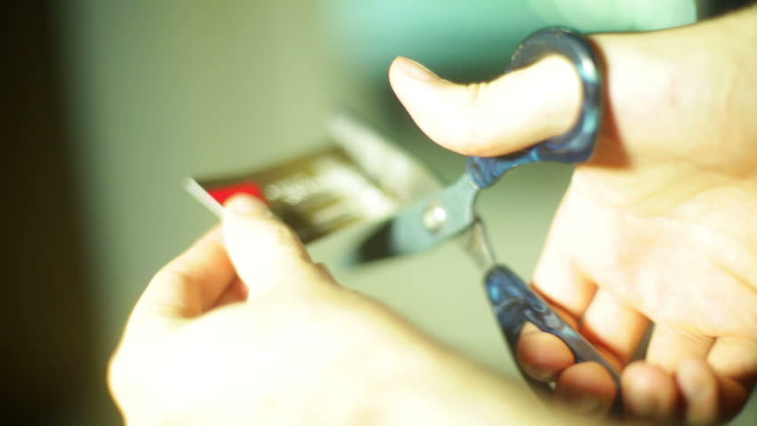cutting up a credit card. Credit card defocused on purpose. Royalty-Free Stock Footage #2620409