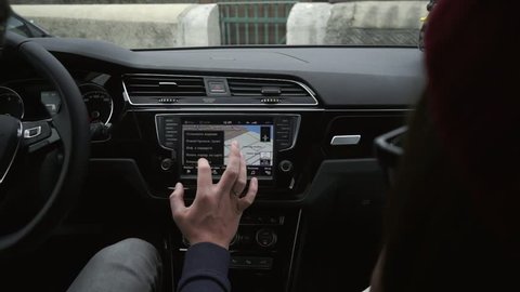 Man's hand using touch screen monitor to adjust GPS in the car