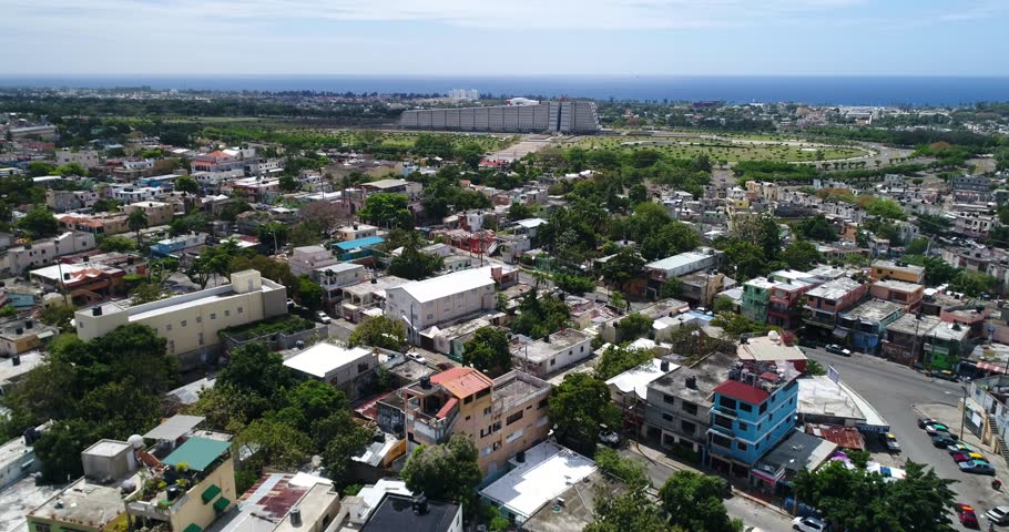 Aerial flight from dense Santo Domingo neighborhoods toward the Columbus Lighthouse and landscaped grounds, 2017.