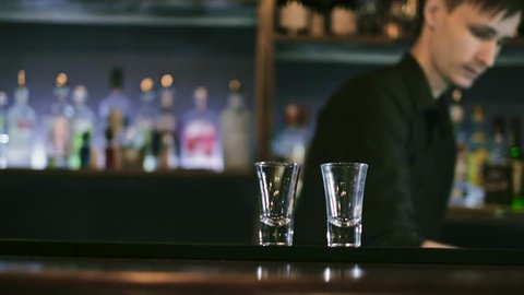 The barman prepares a cocktail and sets it on fire