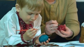 Children with their father paint traditional Easter eggs in an ancient way - Scratching