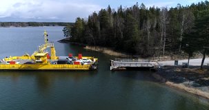 Skåldö cable ferry, Cinema 4k aerial view of a yellow cable ferry, docking, at the harbor, in Skaldo, in the tammisaari archipelago, in Finland