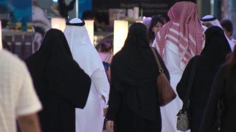 DUBAI, UAE - CIRCA FEBRUARY 2016: A busy modern mall in Arabia despite the effects of the low oil price on the economy, showing a large Emirati family wearing traditional Arab dress.