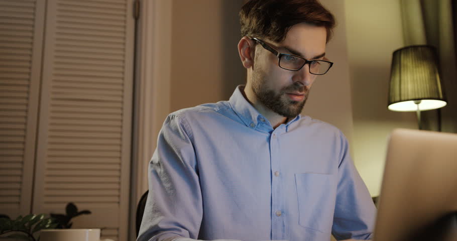Young man typing on his laptop in office. Beatiful business man writing on notebook.