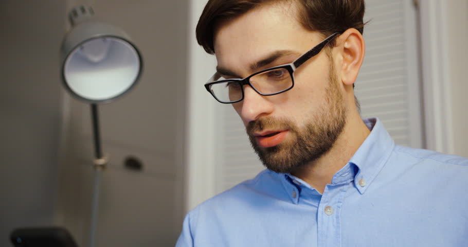 Youg man searching something on cell phone. Attractive business man talking on smart phone. Close up.