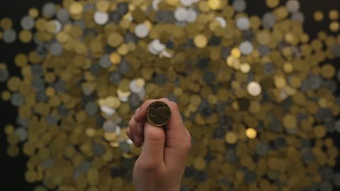Man throw coins down on coin background. Gold coins fall in down in slow motion. Close up. Top view.