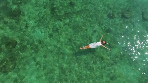 Top Aerial View. Young Woman in White Dress Swimming in Turquoise Sea.