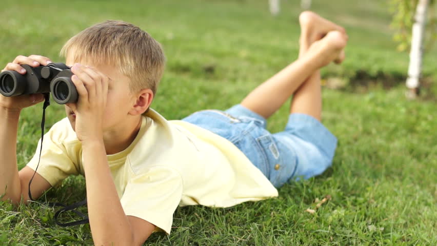 Boy looking through binoculars outdoors
