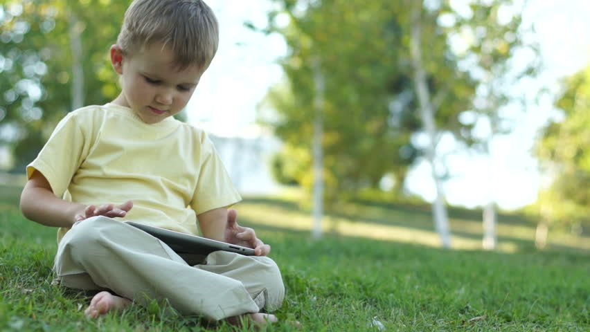Cute boy using a tablet computer outdoors
