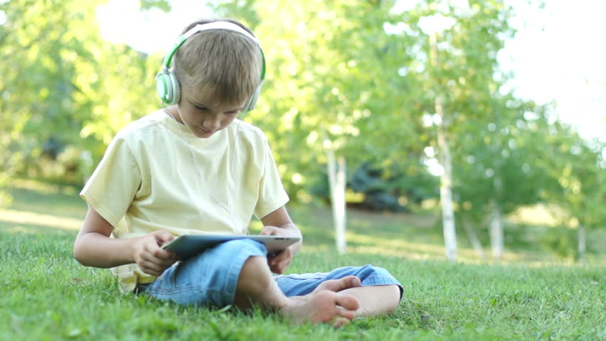 Boy online with tablet pc outdoors
