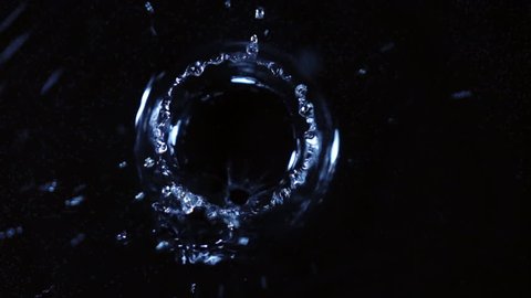 Water drops are falling and making ripple. Closeup top view. Shooing with high speed camera. Extreme slow motion.