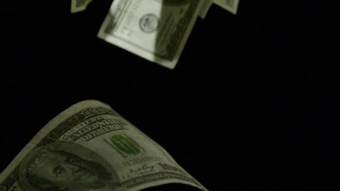 Slow motion of falling down 100 dollar bills on black background.