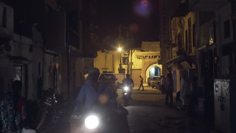 INDIA - CIRCA JUNE 2016 - Motorbikes drive in dark street at night, Mathura, India