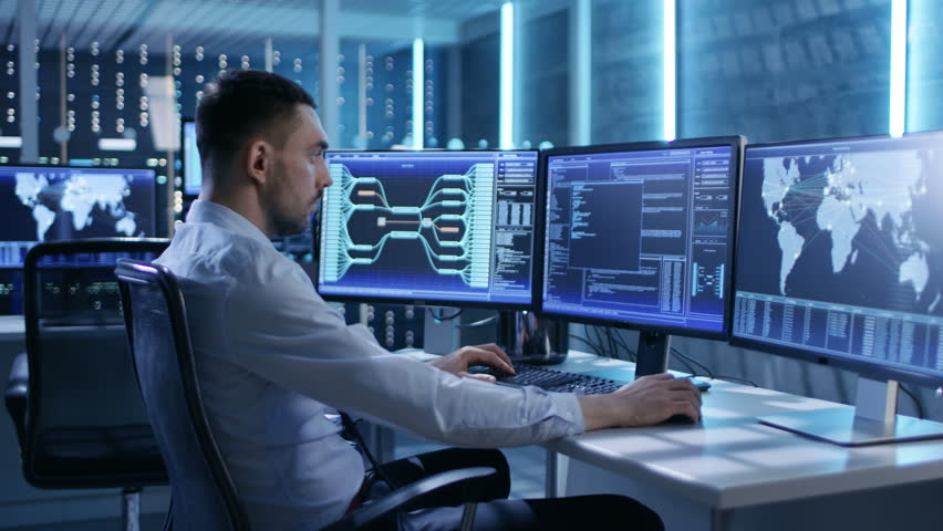System Security Specialist Working at System Control Center. Room is Full of Screens Displaying Various Information. He Shares His Opinions with Colleagues. Shot on RED EPIC-W 8K Helium Cinema Camera. | Shutterstock HD Video #26262158