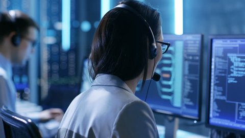In the System Control Center Technical Support Team Gives Instructions with the Help of the Headsets. Possible Air Traffic/ Power Plant/ Security Room Theme. Shot on RED EPIC-W 8K Helium Cinema Camera