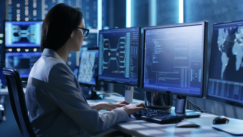Female System Engineer Controls Operational Proceedings. In the Background People Working and Monitors Show Various Information. Shot on RED EPIC-W 8K Helium Cinema Camera. | Shutterstock HD Video #26263034