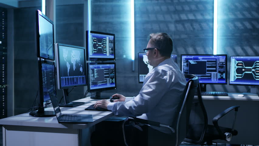 Two Technical Engineers and Third Taking His Place In Monitoring Room. Space is Full of Working Displays with Various Data Showing on Them.  Shot on RED EPIC-W 8K Helium Cinema Camera. Royalty-Free Stock Footage #26263346