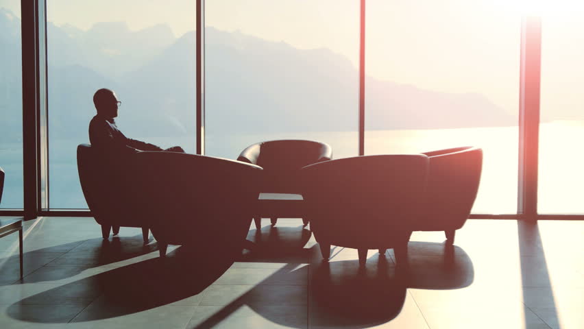 silhouette of two business people talking together sitting in modern lobby hall at sunset light. financial sales corporate concept background  Royalty-Free Stock Footage #26264675