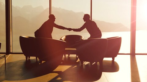 business partners meeting inside modern lobby hall chatting over contract agreement deal. businessman handshaking scene background