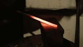 The smith beats the hammer on the metal workpiece, giving it a shape. Making blacksmith ticks on the anvil. Video with a sound
