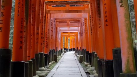 POV SLOW MOTION: Walking inside Fushimi Inari Shrine or Fushimi Inari Taisha, a Shinto shrine in Kyoto, Japan. A Japanese monument, famous for its thousands of vermilion torii gates.