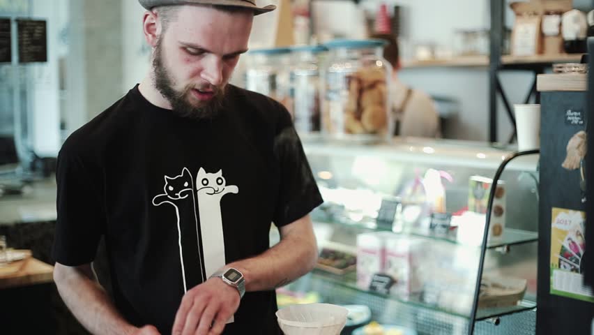 Portrait Barista prepares Pour over, talks about the cooking process, looks at the camera. Beard. kemex