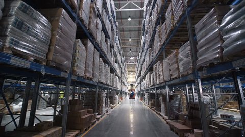 big factory warehouse. store Aisles. Camera travels inside a large store. Warehouse shipping. Large warehouse logistics terminal Interior. Moving camera person operator forklift. Worker truck man 4k 