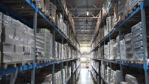 big factory warehouse. store Aisles. Camera travels inside a large store. Warehouse shipping. Logistics business and shipping facility with forklift to move boxes and goods. cargo mail Industry 4k