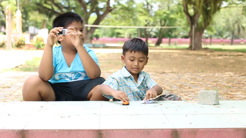 Cute little asian boy playing with car toy