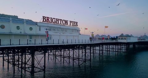 Brighton Pier Aerial view at sunrise. Early morning sunrise at the iconic Pier in Brighton with seagulls flying in 4k. 