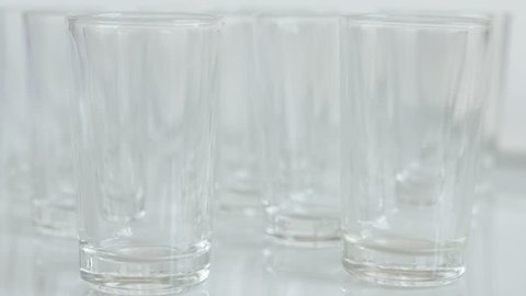 Close-up of shot glasses on white background 4K 2160p 30fps UltraHD tilting footage - Transparent spirits or liquor drink glass slow tilt 3840X2160 UHD video