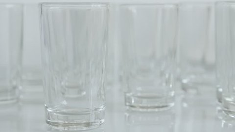 Transparent spirits or liquor drink glass 4K 2160p 30fps UltraHD tilting footage - Close-up of shot glasses on white background slow tilt 3840X2160 UHD video