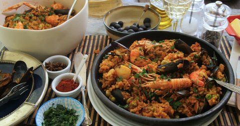 Dolly view of a Spanish seafood paella: mussels, king prawns, langoustine, haddock
