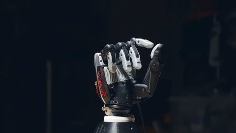 The camera is slowly moving around the robot hand, showing how it is opening the fingers. The thumb is moving to the right.