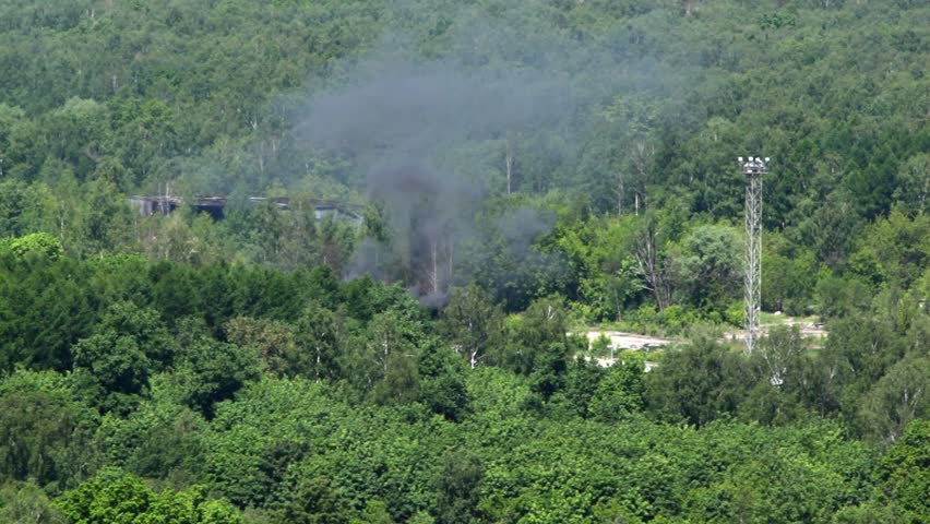 black fuming steam comes out of trees, and cars driven on rails