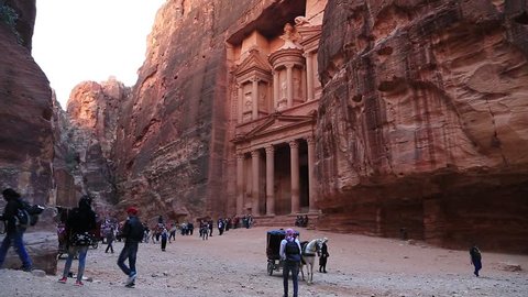 JORDAN, PETRA, DECEMBER 5, 2016: Horse and people near Al Khazneh or the Treasury at Petra, originally known to Nabataeans as Raqmu - historical and archaeological city in Hashemite Kingdom of Jordan