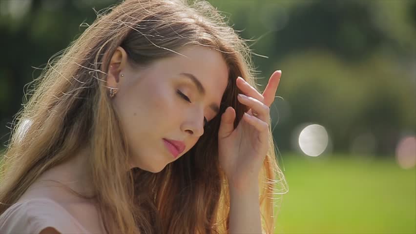 Glamour girl sits on a lawn and works on her laptop in slow motion