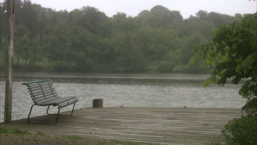 A man with an umbrella walking by water