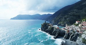 aerial view of travel landmark destination Vernazza, a small mediterranean sea town, Cinque terre National Park, Liguria, Italy. Afternoon sunny and cloud weather. 4k aerial drone side video shot