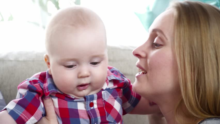 Young mother playing with 6 months old son closeup