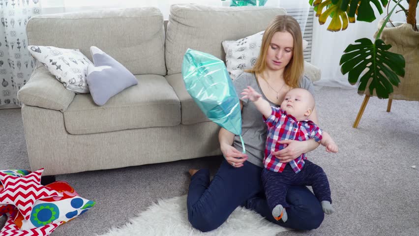 Young mother playing with her 6 months old son with baloons