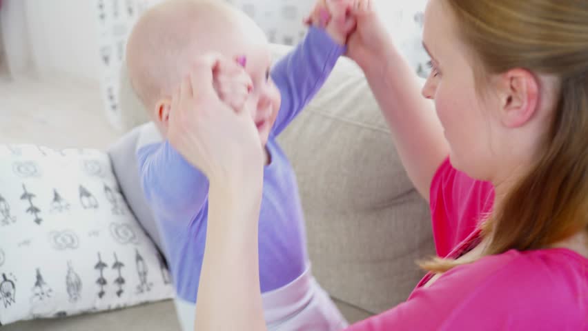 Pretty mother playing with 6 months son closeup