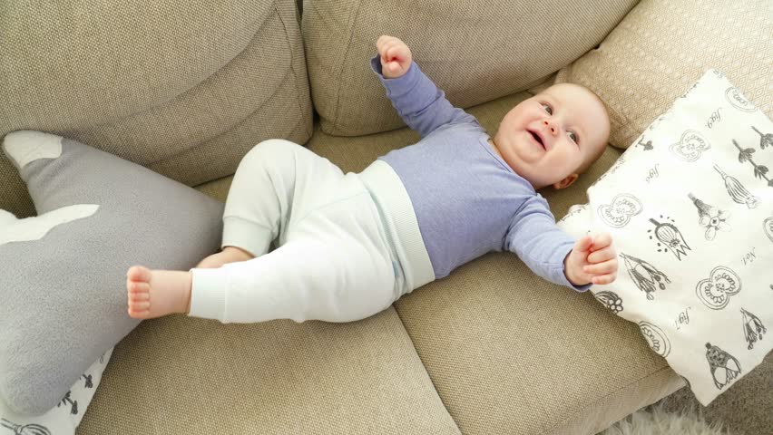 Pretty cute little child boy of 6 monts laying on sofa