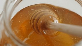 Close-up of kitchen spiral utensil in glass honey jar 4K 2160p 30fps UltraHD footage - Wooden dipper in sweet food substance 3840X2160 UHD video